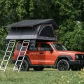 Rondane Wide taktelt oppslått på oransje SUV – dobbel stige og full høyde i grønt skogsområde.