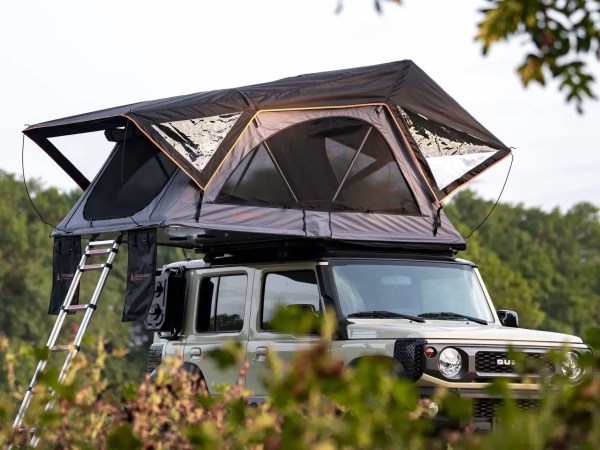 To biler med Rondane taktelt oppslått – camping i grønt skogsområde.