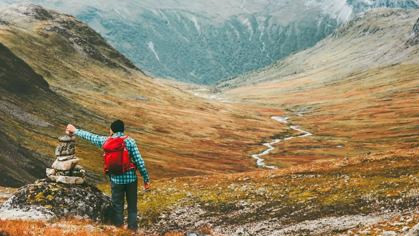 person som legger stein på varde